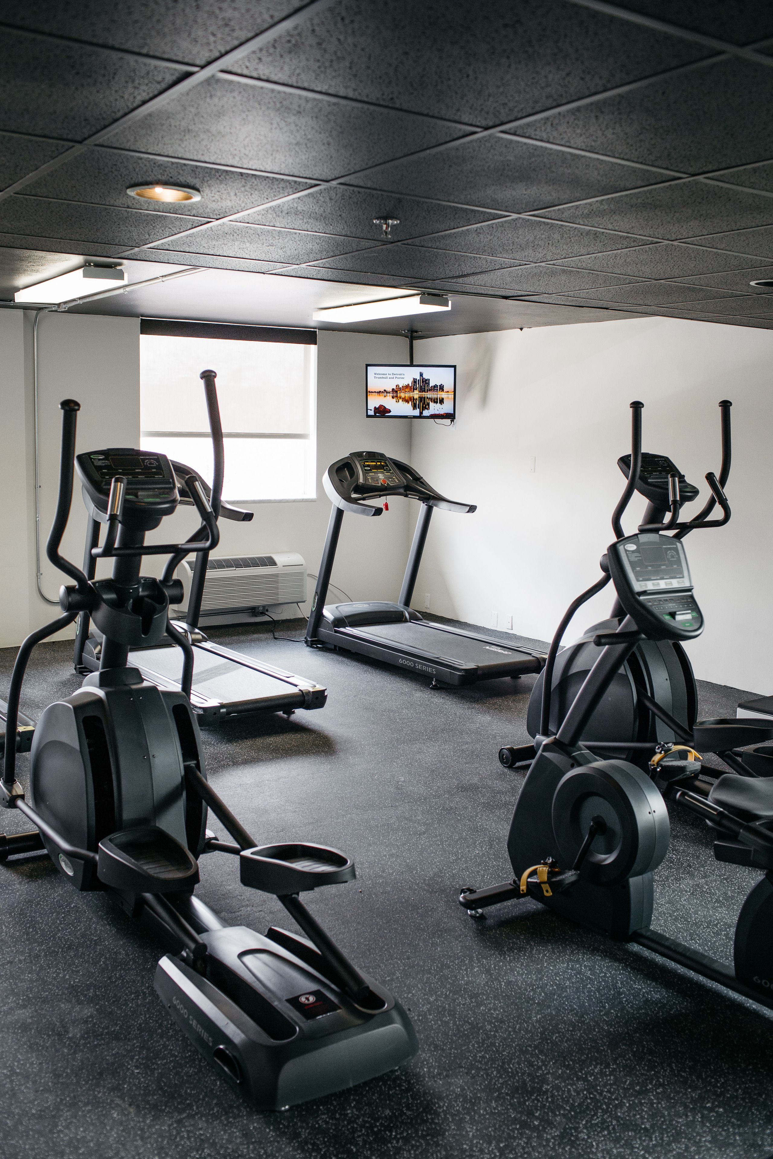A gym with treadmills, stationary bikes, and an elliptical machine.