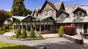 A large stone building with multiple windows and a covered patio area.