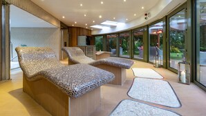 Un área de descanso moderna con techo alto, tragaluces y grandes ventanales que ofrecen vistas al exterior.