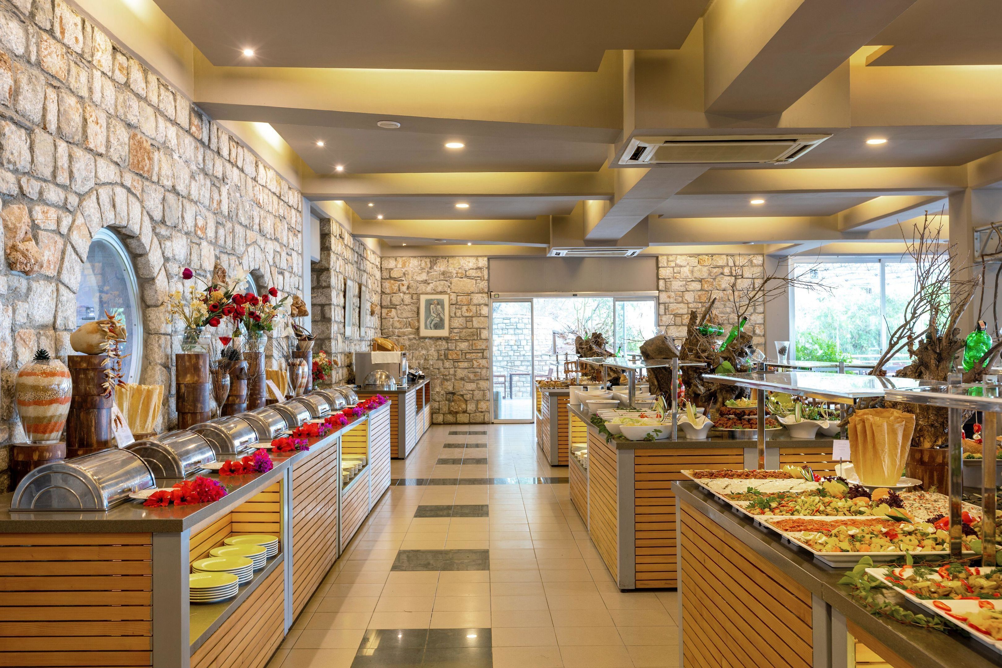 Un bufé con diferentes opciones de comida, una pared de piedra y una barra de madera.