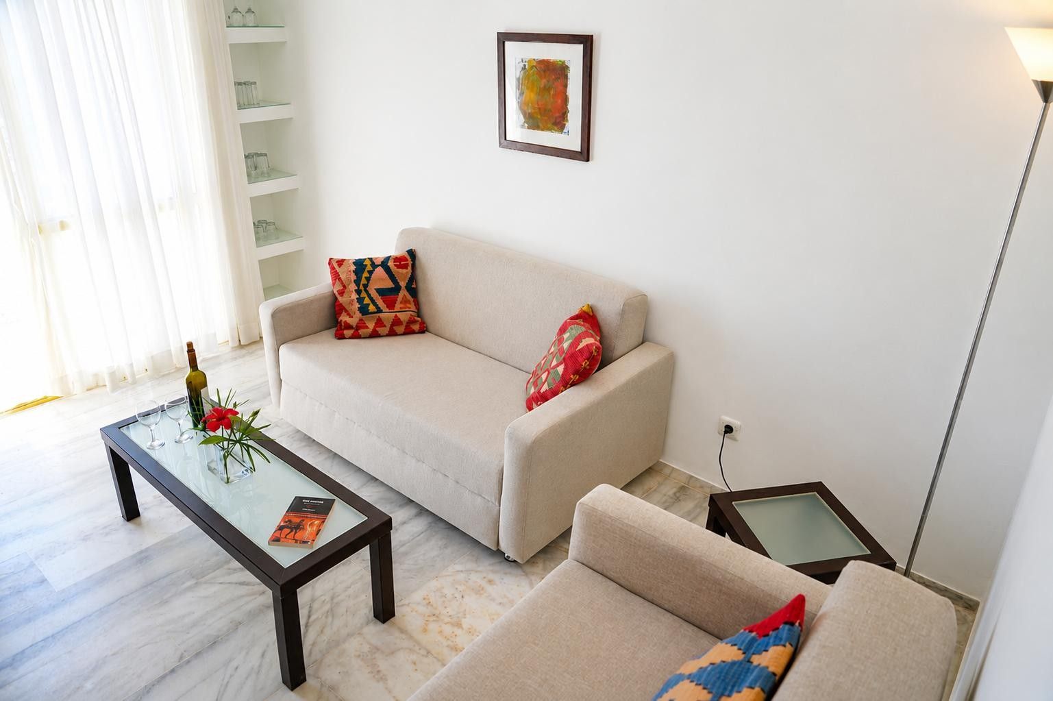 A living room with a sofa, a coffee table, a side table, and a floor lamp.