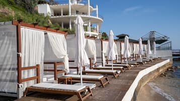 Plage privée, cabines (en supplément), chaises longues, parasols