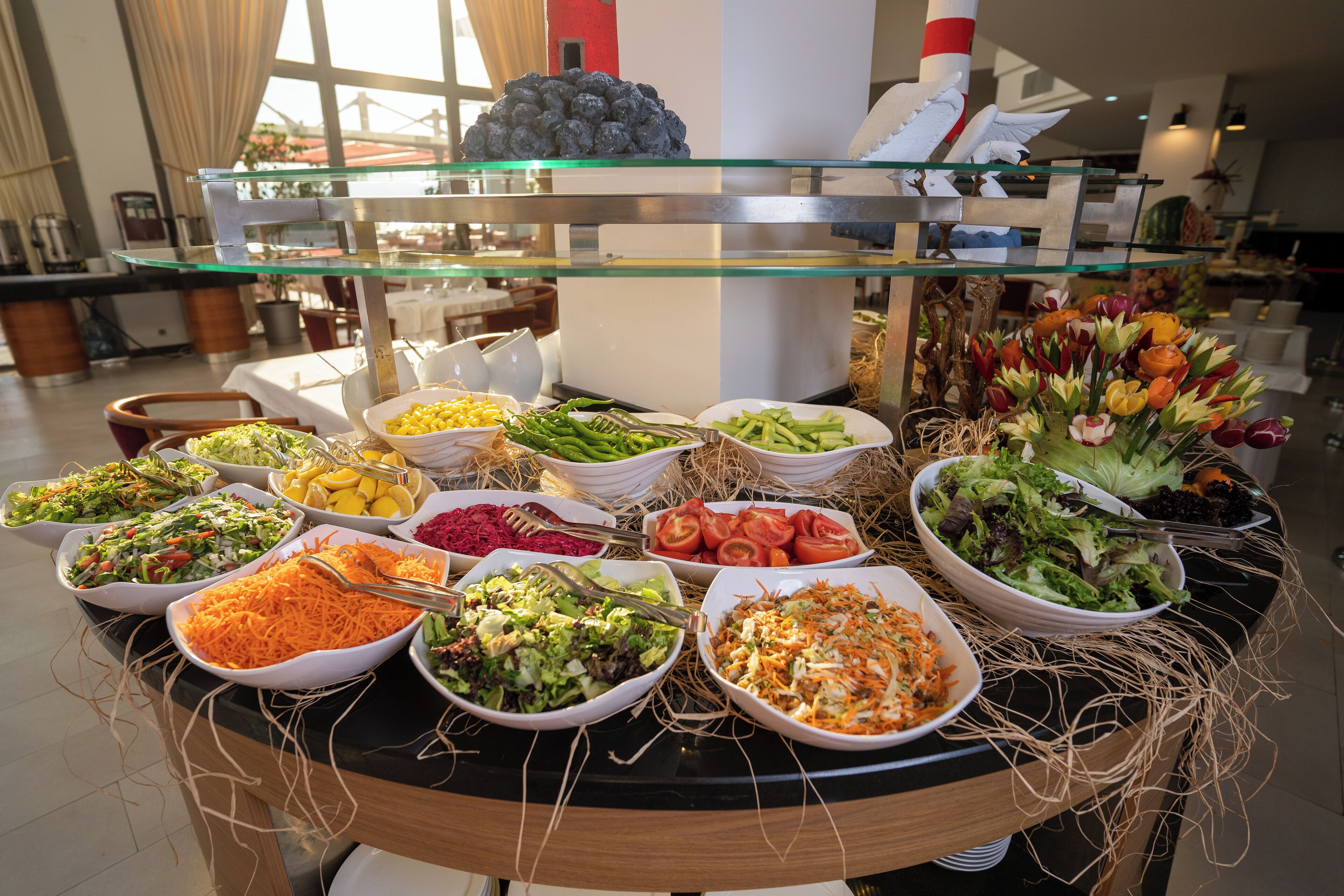 A buffet with various dishes including salads, vegetables, and fruits.