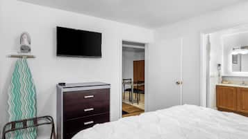 Un dormitorio con cama, cómoda, televisor y espejo.