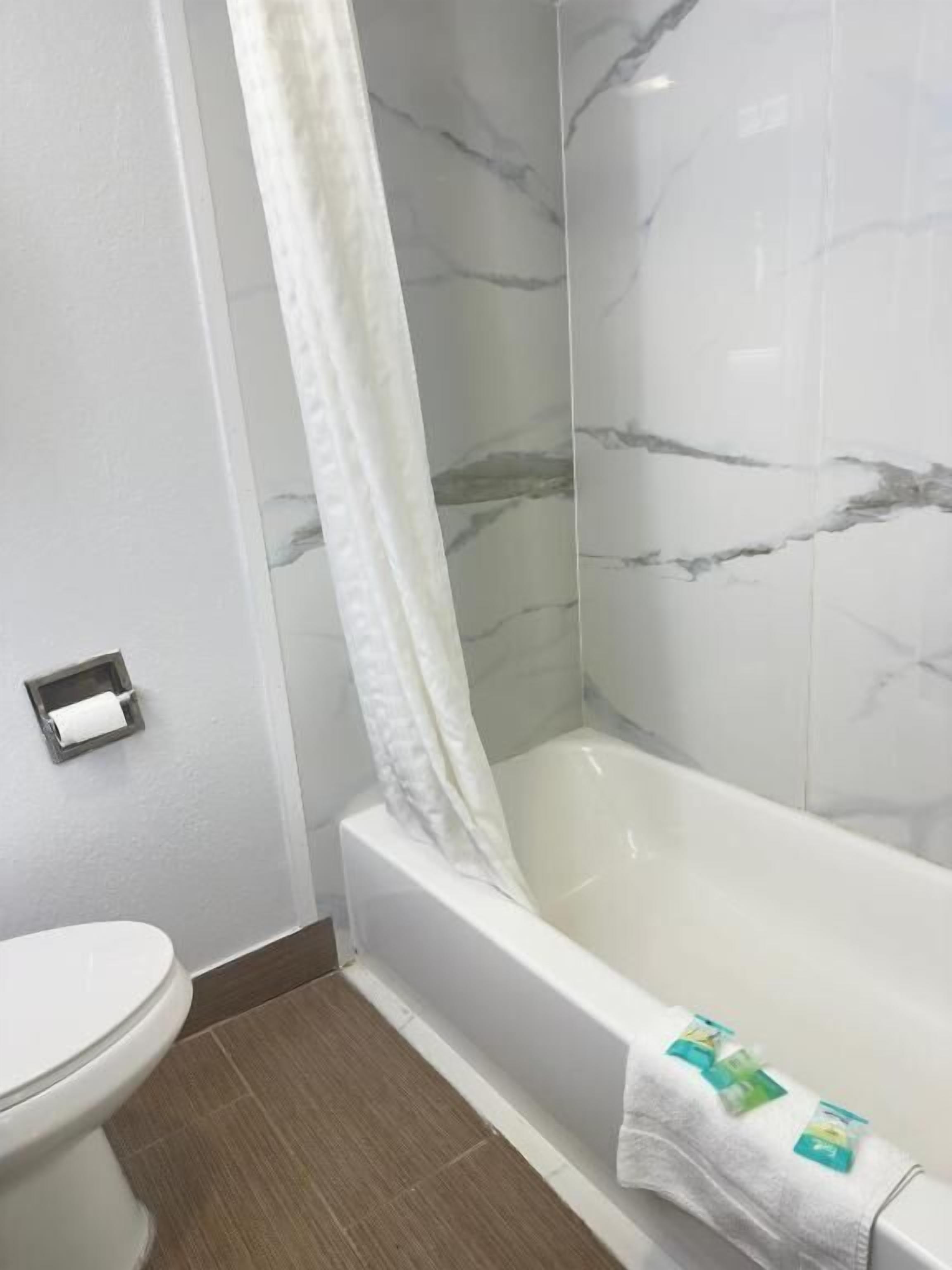 Een bad/douchecombinatie, gratis toiletartikelen, handdoeken