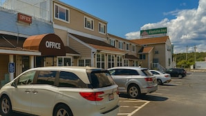 A parking lot with several cars, a building with an 'Office' sign, and a 'Everest Inn' sign. - Bourne Bridge Inn  (Buzzards Bay)