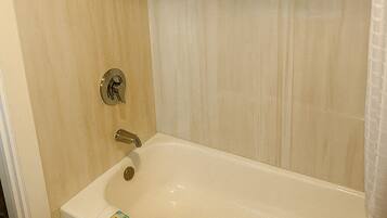 A bathroom with a bathtub, a shower, and a toilet.