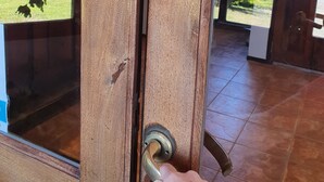 Se abre una puerta de madera con un tirador de latón.