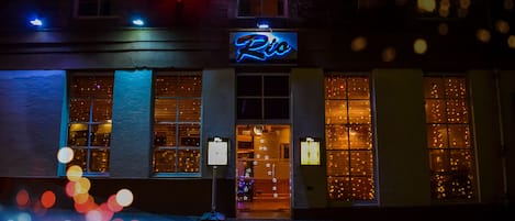 Um edifício com um letreiro de neon que diz "Rio" e uma entrada visível.