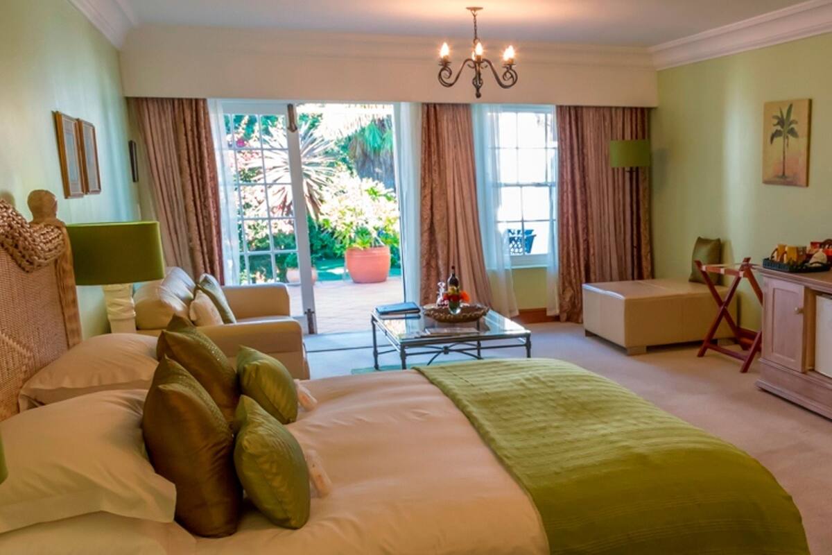 A hotel room with a bed, a desk, a television, and a view of the outdoors.