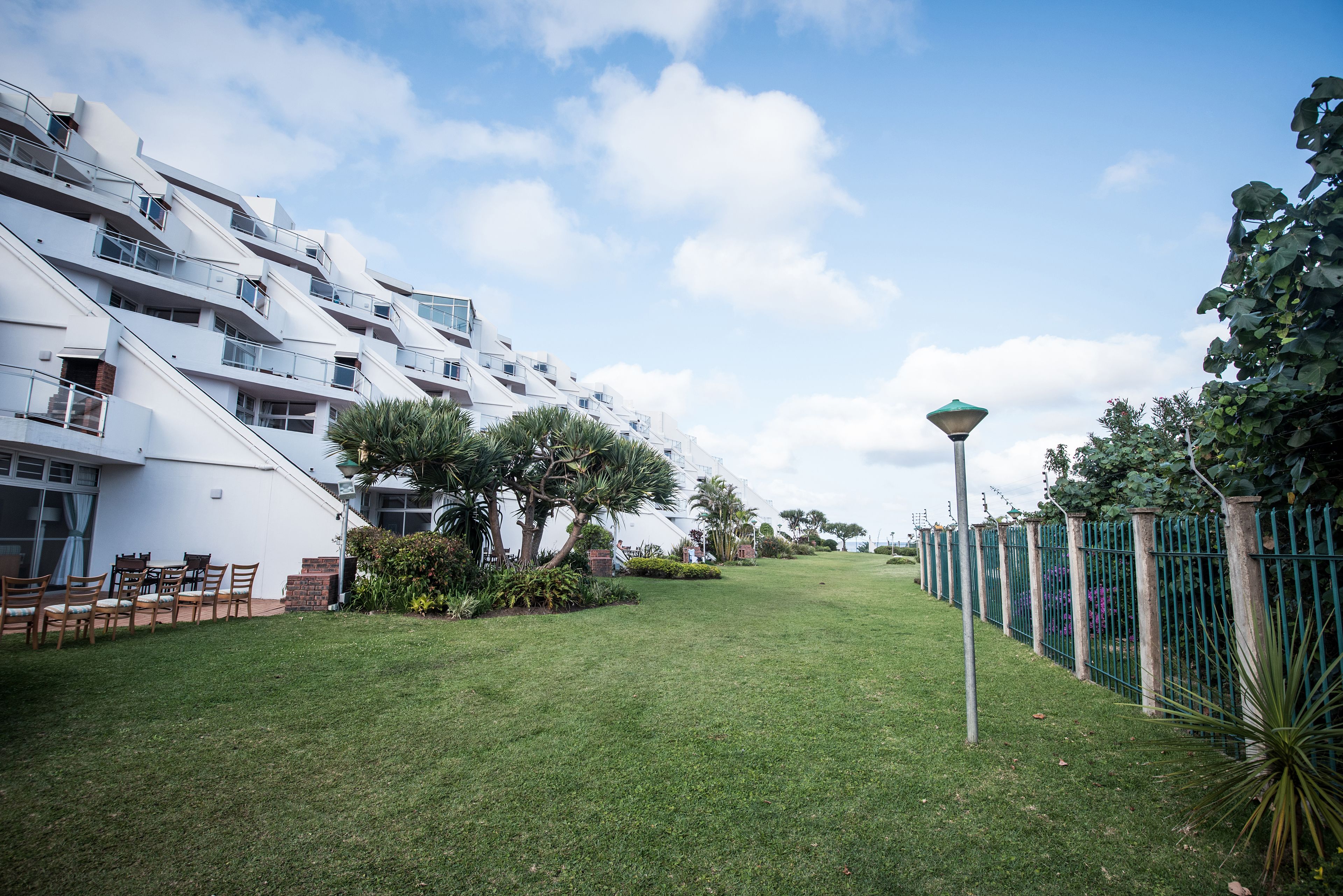 Un bâtiment moderne doté de nombreux balcons et d’une pelouse bien entretenue.