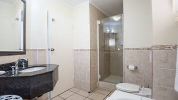 A bathroom with a sink, toilet, and shower.
