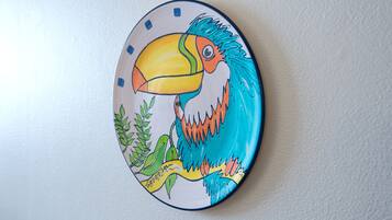 A wall-mounted plate with a colorful toucan illustration.