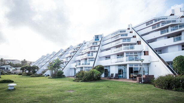 Un bâtiment moderne à plusieurs étages, doté d’une architecture originale à pans inclinés, de balcons et de grandes fenêtres.