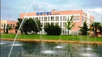 A hotel with a large sign reading "HOTEL" and a reflection in the water in front.