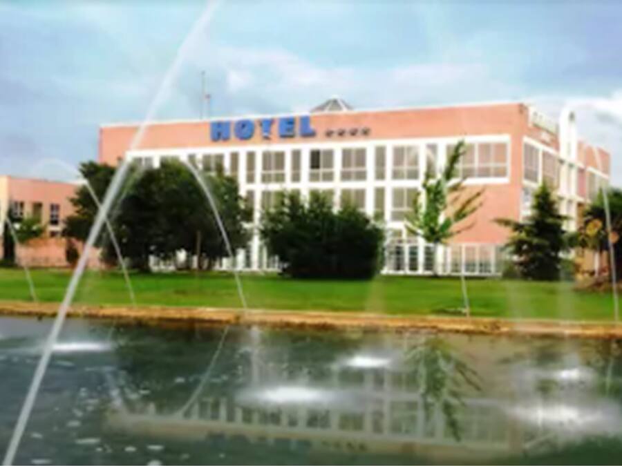 A hotel with a large sign reading "HOTEL" and a reflection in the water in front.