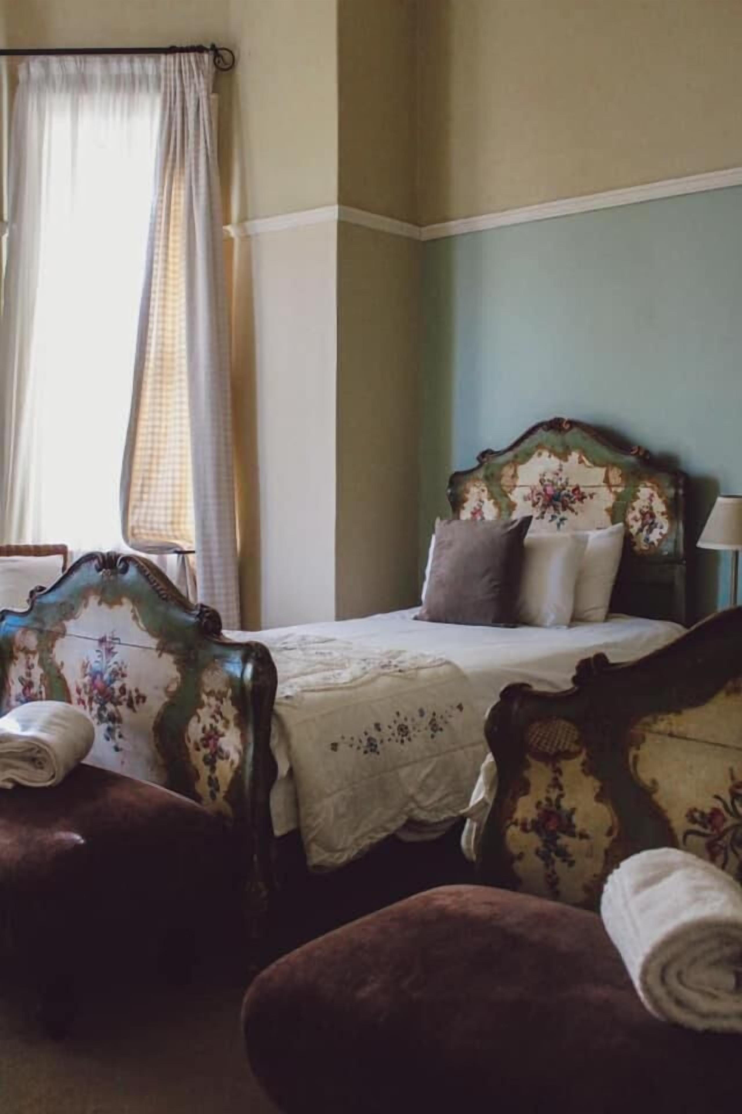 A bedroom with a bed, a chair, and a nightstand.