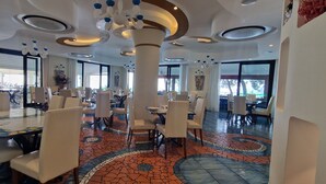 A spacious dining area with high ceilings, modern chandeliers, and a mosaic floor. - La Conca Azzurra (Conca dei Marini)