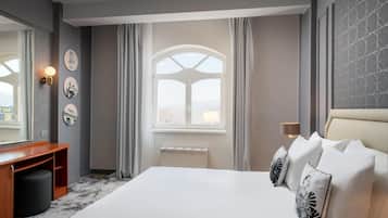 أغطية فراش متميزة وميني بار وخزنة داخل الغرفة ومكتب