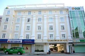 En bygning med flere etager, med skiltning for Saigon Tourane Hotel og en Vietabank bank i stueetagen.