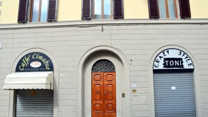 Fachada de edificio con dos escaparates: 'Caffè Cimabue' y 'Crazy Style Toni'.
