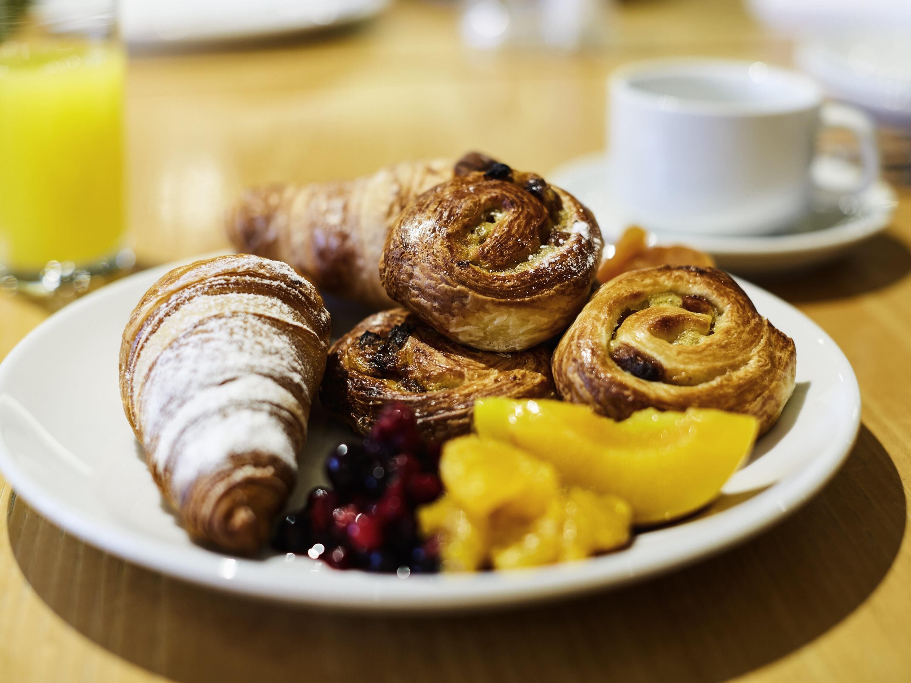 A plate of pastries and fruit on a table.