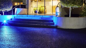 The West Grange Hotel with a well-lit entrance, steps leading up to the doors, and two small trees in front. - Mercure Newbury West Grange Hotel (Thatcham)