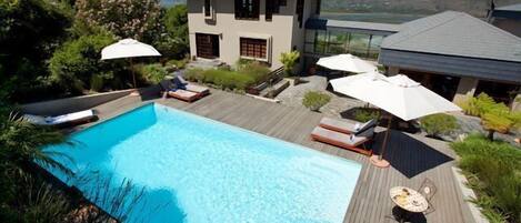 Una piscina al aire libre, sombrillas, tumbonas