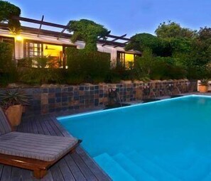 A swimming pool with a wooden deck and a pergola. - Kanonkop Guest House (Knysna)