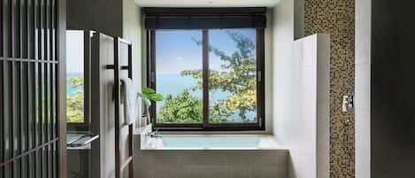 Un baño moderno con un ventanal grande, una bañera y una zona de ducha.
