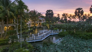 A resort with a water feature, palm trees, and a bridge. - Rawi Warin Resort and Spa (Ko Lanta)