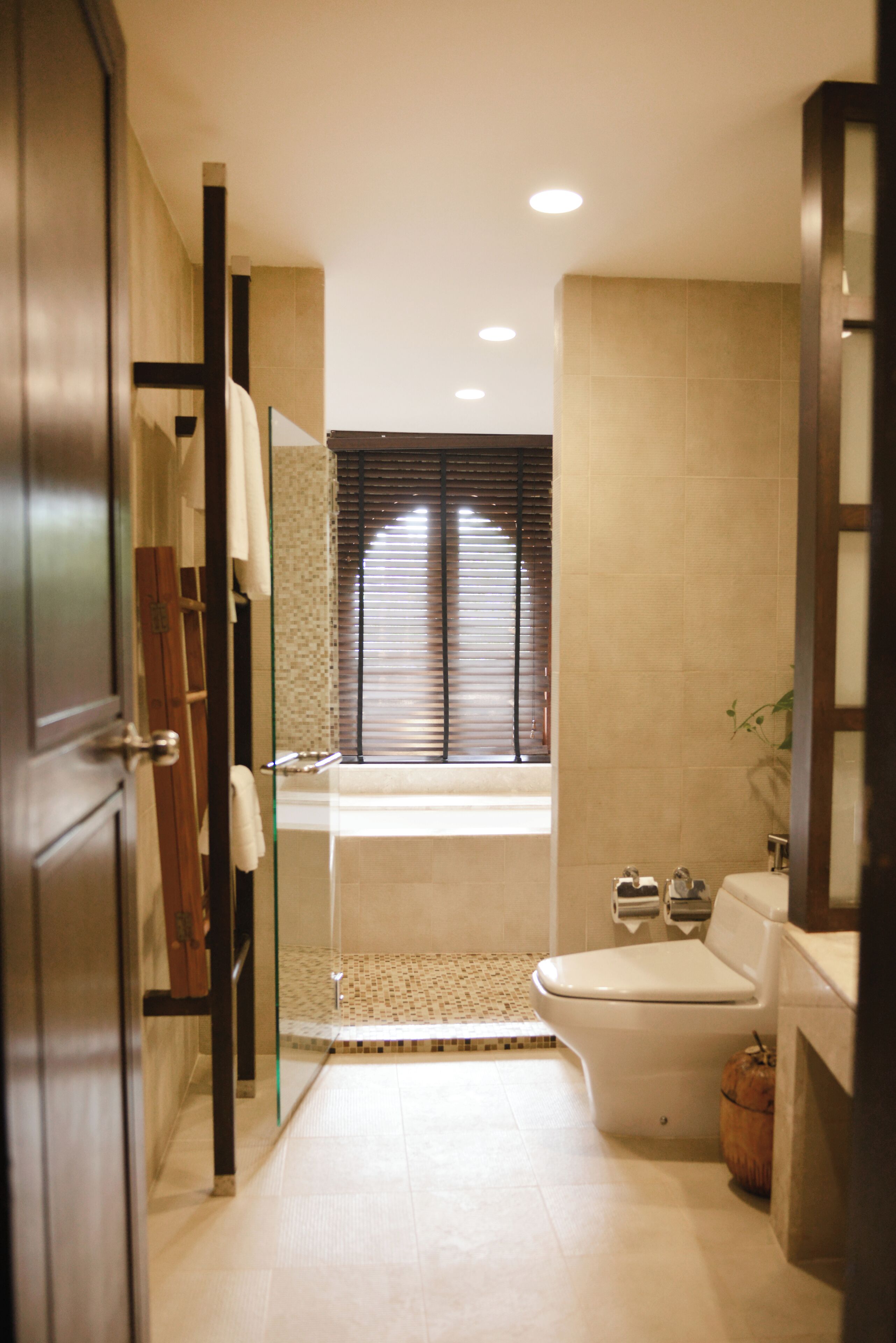 Een moderne badkamer met een douchecabine van glas, een bad en een toilet.