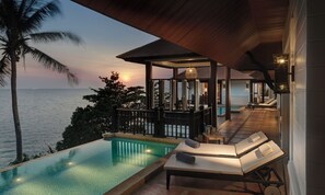 An infinity pool with a view of the ocean at sunset, a lounge area with a table and chairs, and a covered patio with a pool table. - Rawi Warin Resort and Spa (Ko Lanta)