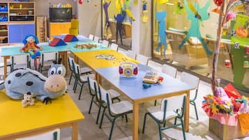 Children can play and learn in this spacious room with a long table, chairs, and a variety of toys.