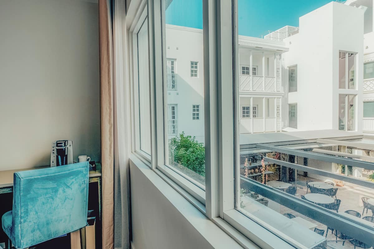 A room with a view of a balcony and outdoor seating area.