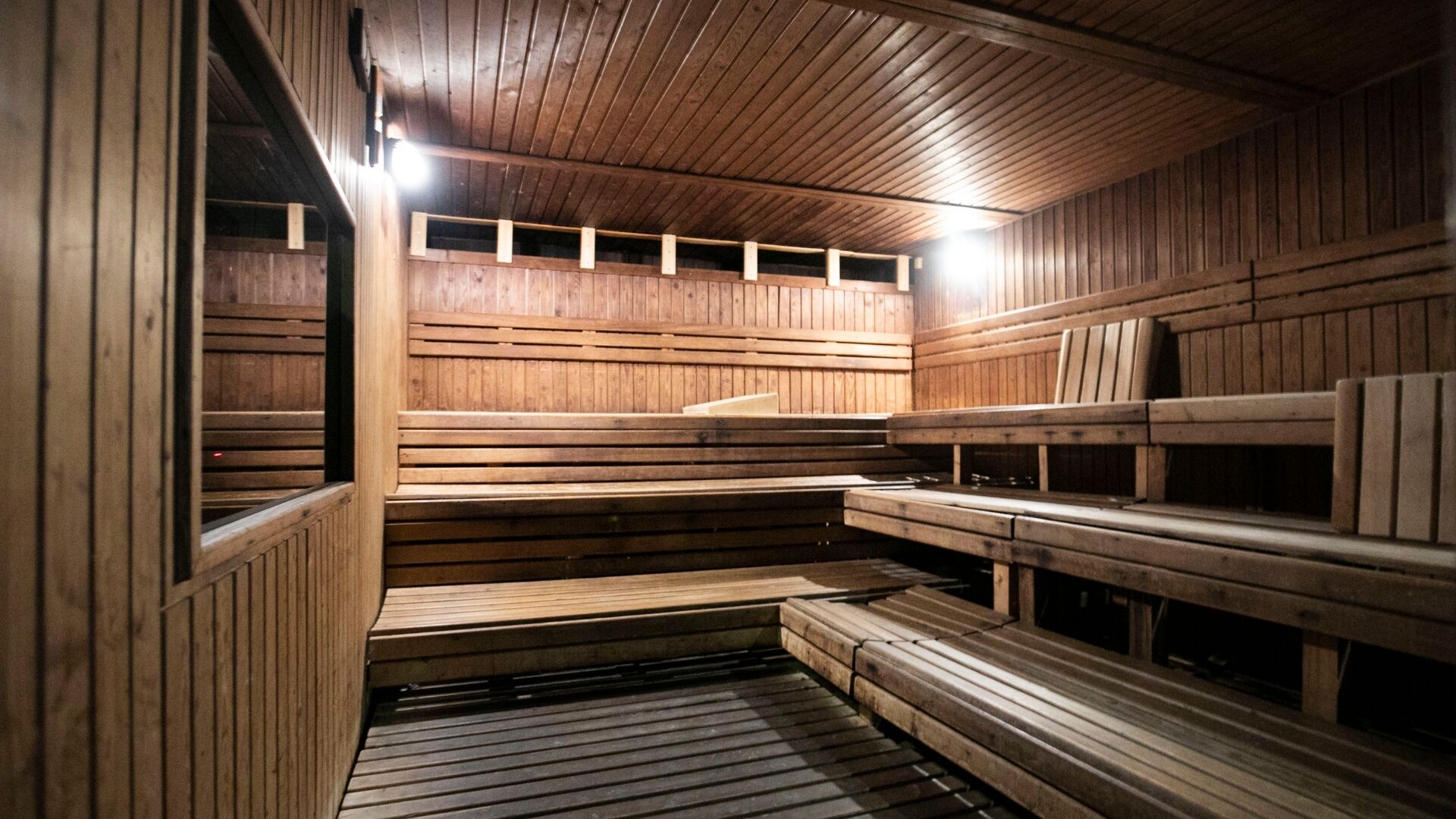 Una sauna con bancos de madera y techo inclinado.