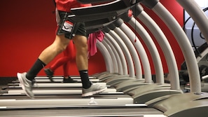 Een loopband met een rode muur op de achtergrond.