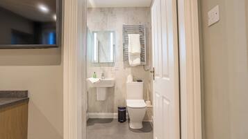 A modern bathroom with a toilet, sink, and towel rack.