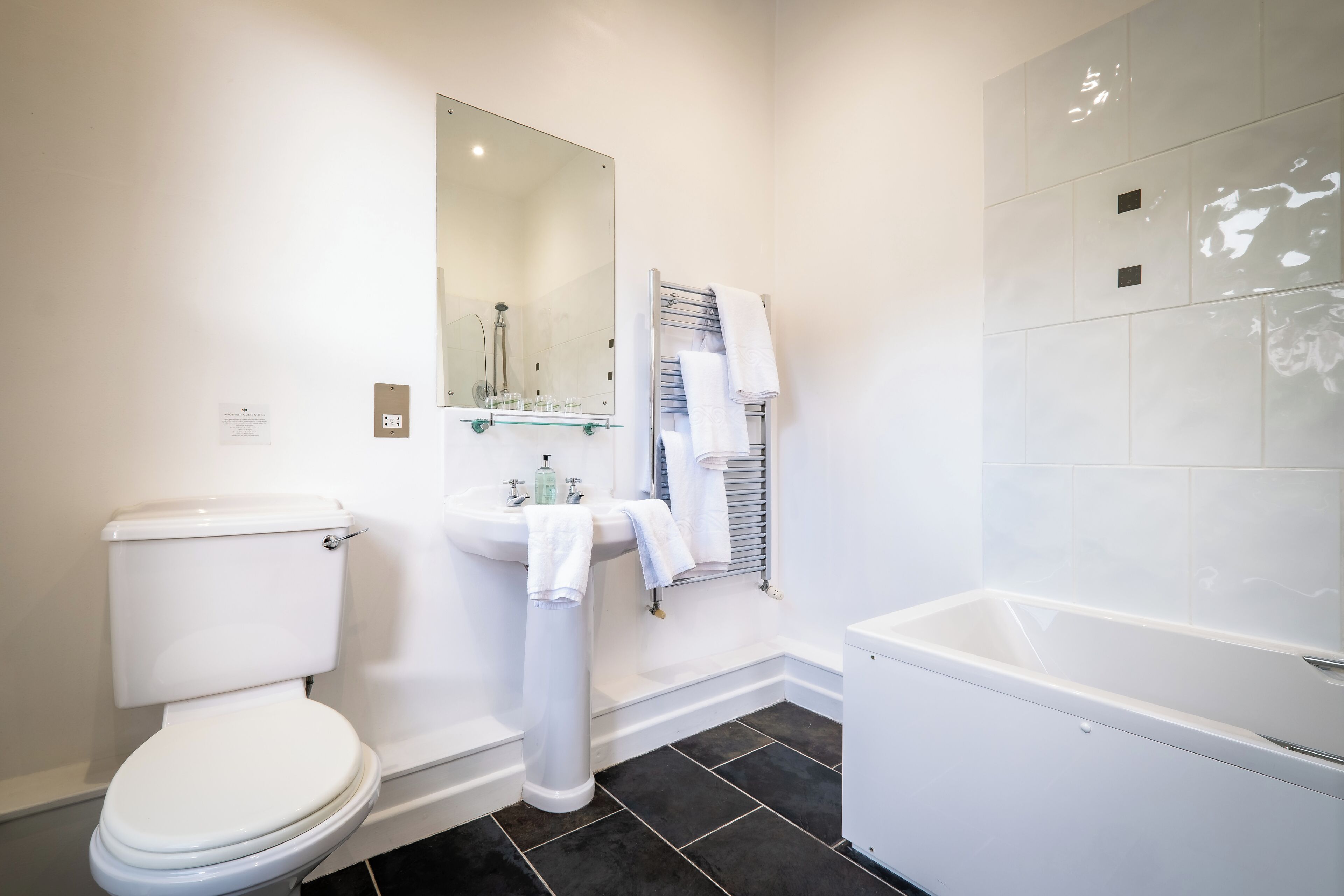 Ein modernes Badezimmer mit Toilette, Waschbecken und Badewanne.