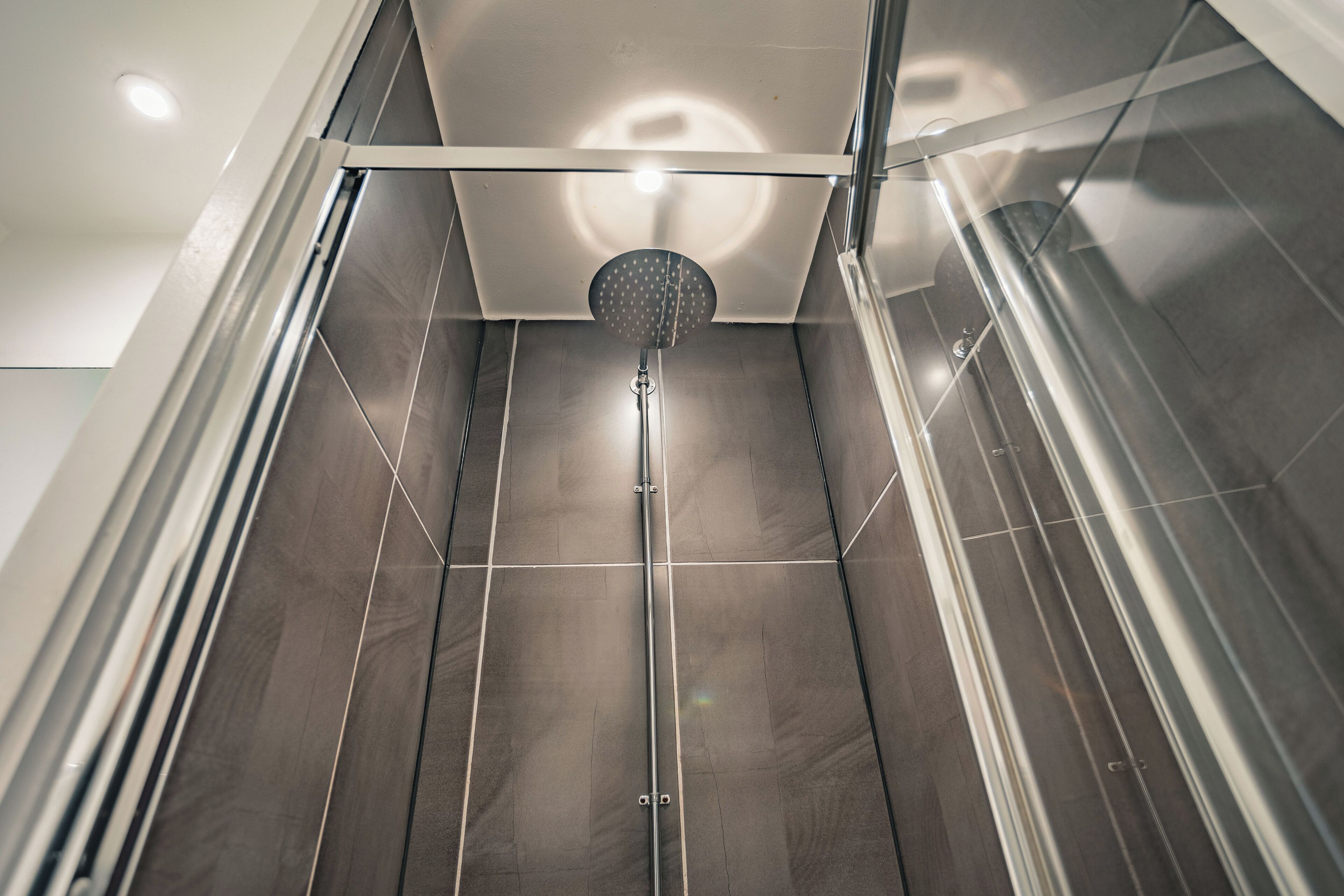A modern shower with a glass enclosure and a visible showerhead.