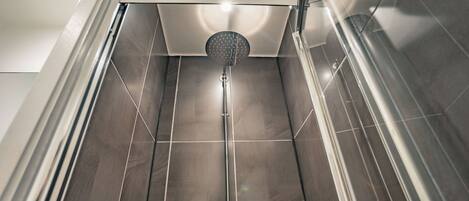 A modern shower with a glass enclosure and a visible showerhead.