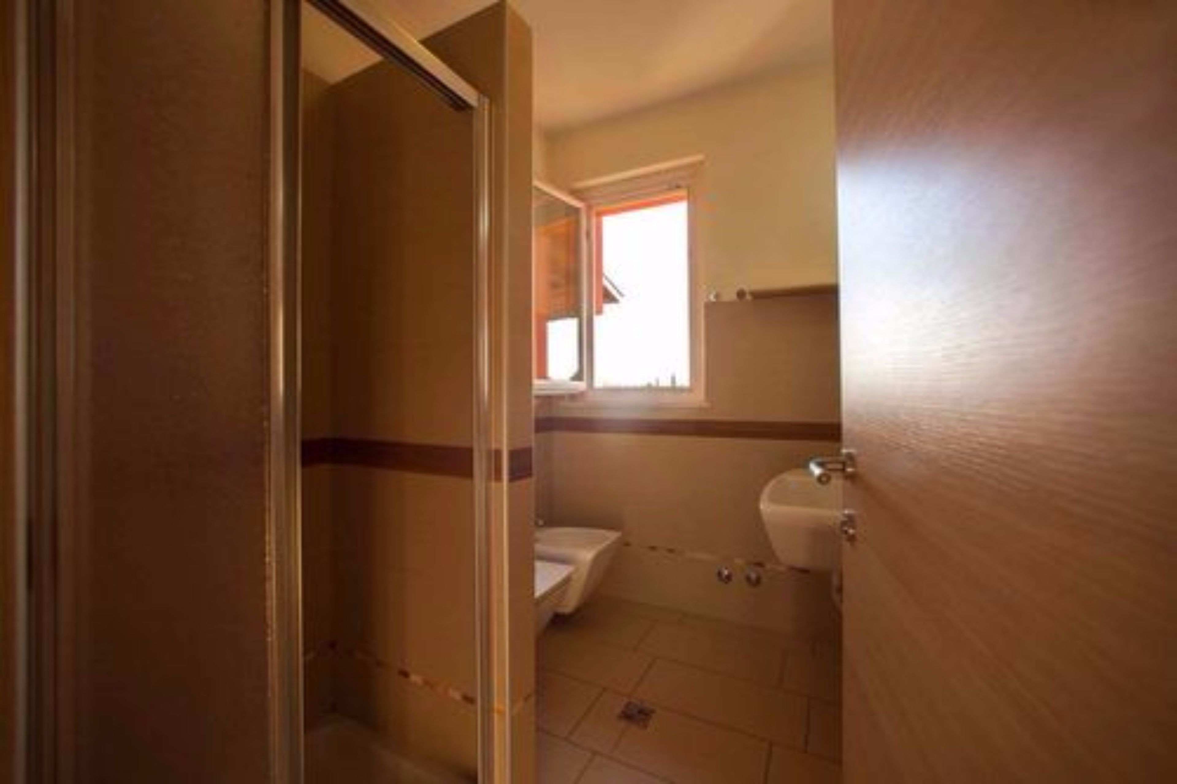 A bathroom with a toilet, sink, and shower.