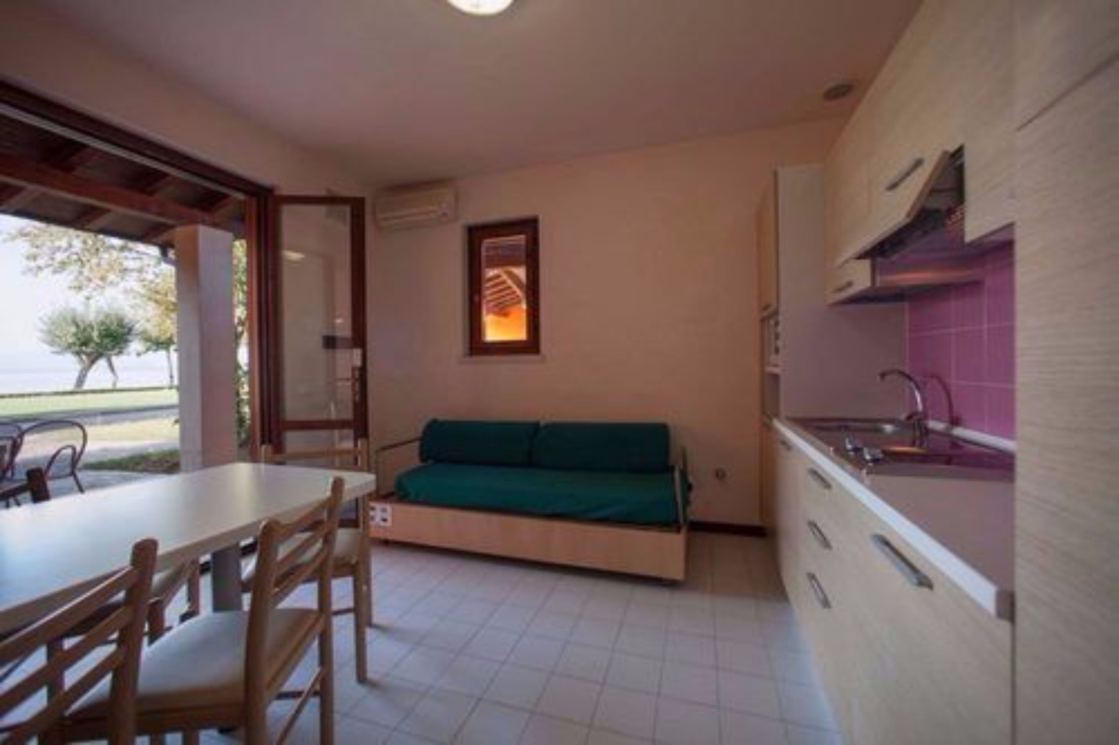 Une cuisine compacte avec un coin repas, un canapé et une fenêtre donnant sur un beau paysage.