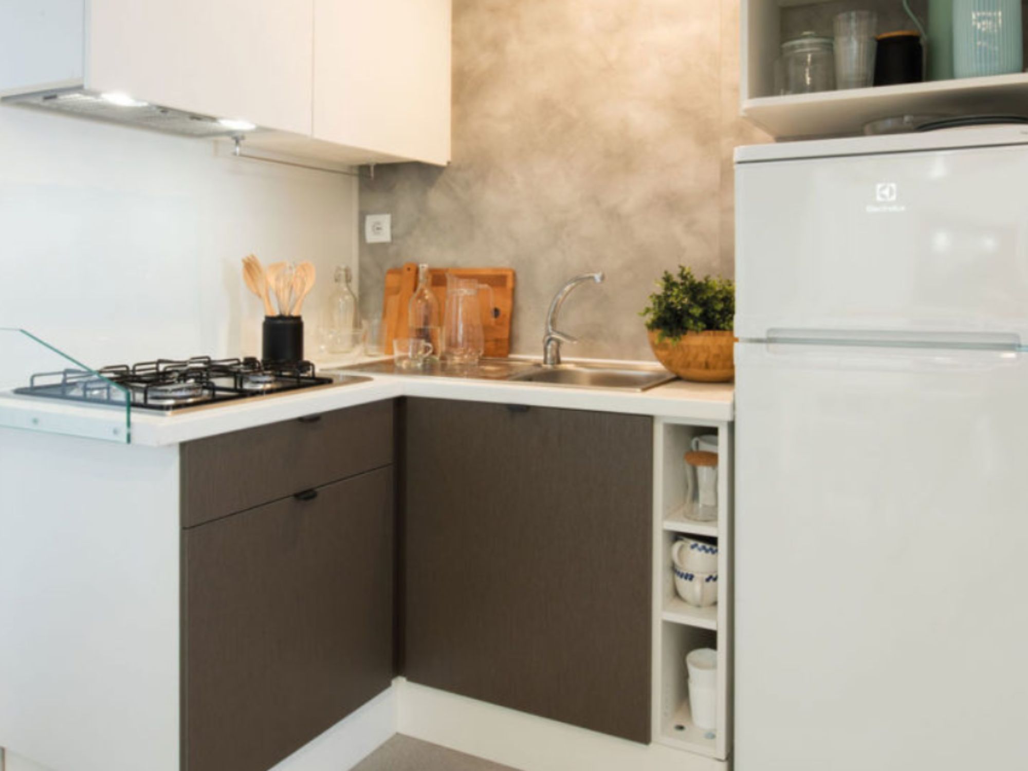 A compact kitchen with a gas stove, a sink, and a refrigerator.