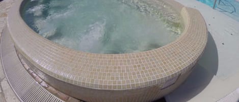 Ein großer Außenpool mit einem Whirlbereich.