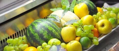 Exhibición de frutas frescas, como sandía, uvas, limones y naranjas.