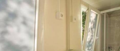 A bathroom with a white sink, a mirror, and a window.