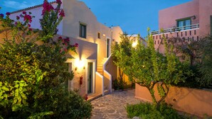 A stone pathway leading to a building with a staircase and a door, surrounded by lush greenery and flowering plants. - Silva Beach Hotel (Hersonissos)
