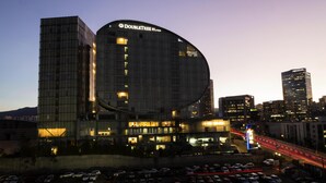 A modern hotel with a curved facade, multiple floors, and a prominent signage. - DoubleTree by Hilton Hotel Mexico City Santa Fe (Mexico City)
