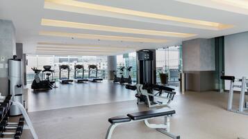 Een moderne sportschool met diverse fitnessapparaten, grote ramen en een ruimtelijke, schone indeling.